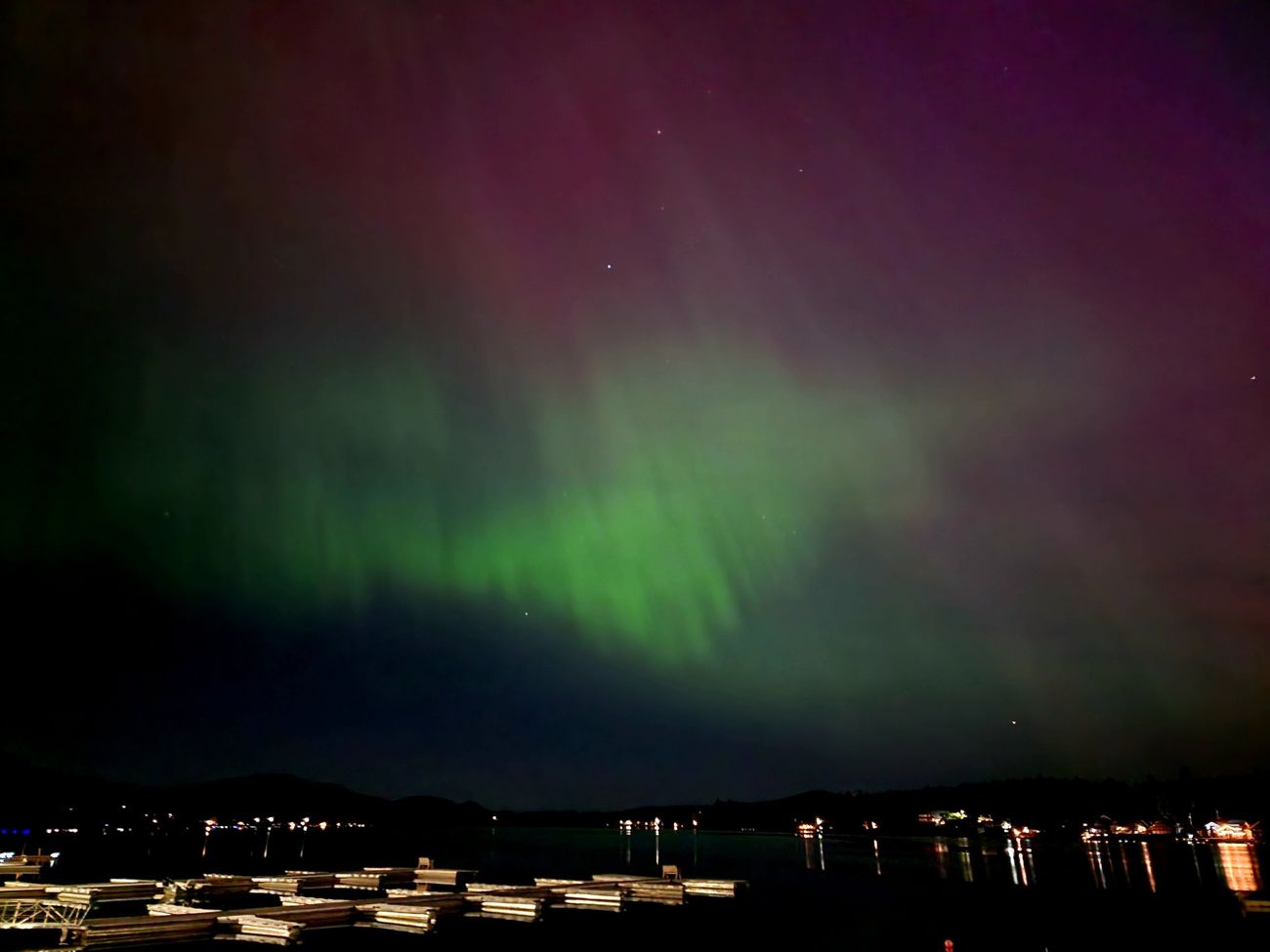 Northern lights glowing green and purple over the docks